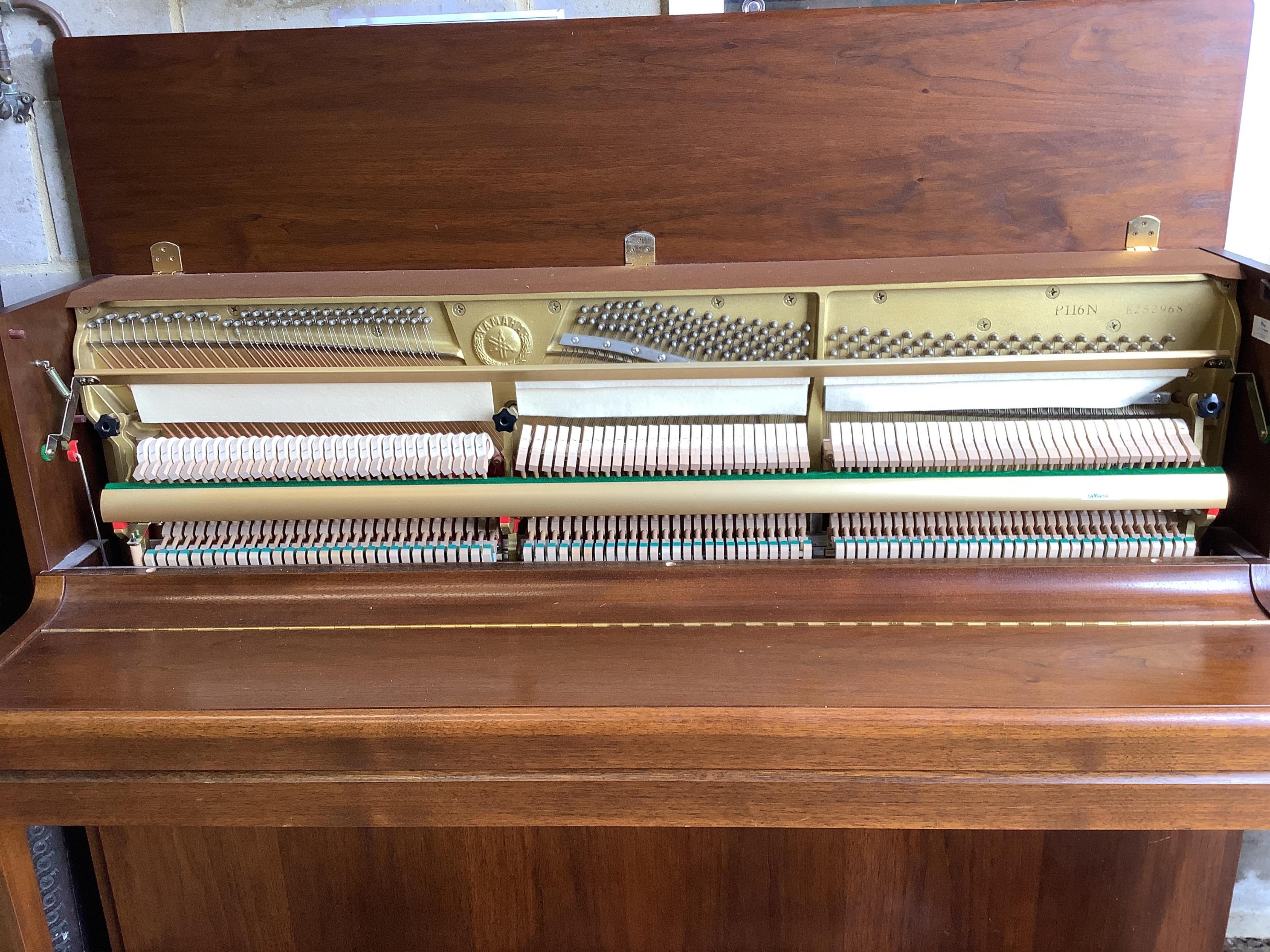 A Yamaha upright piano, model P116N, serial no.E252968, with its original sales booklet and an adjustable piano stool. Condition - good, in very good lightly used condition